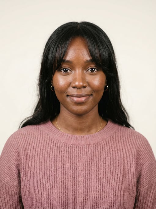 Professional studio headshot of a 24-year-old East African woman with curtain bangs with long dark h