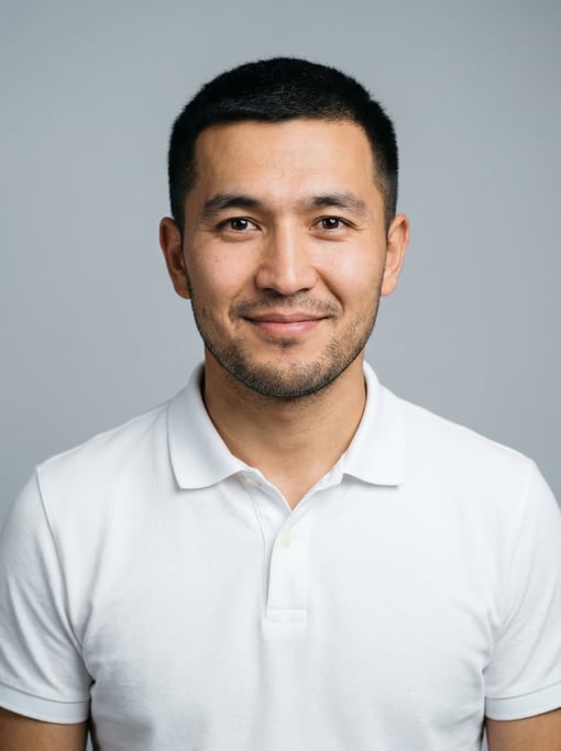 Professional studio headshot of a 27-year-old Central Asian man with short cropped black hair