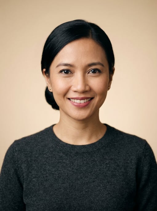 Professional studio headshot of a 37-year-old Indonesian woman with a sleek low bun in black