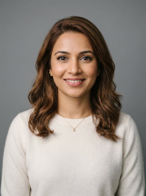 Professional studio headshot of a 33-year-old Indian woman with shoulder-length wavy chestnut hair