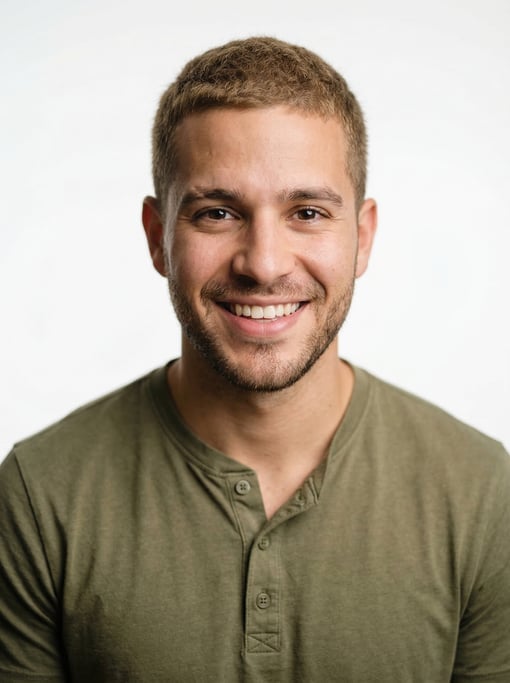 Professional studio headshot of a 24-year-old Puerto Rican man with short cropped sandy brown hair