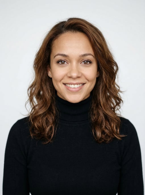 Professional studio headshot of a 27-year-old mixed-race woman with shoulder-length wavy chestnut ha
