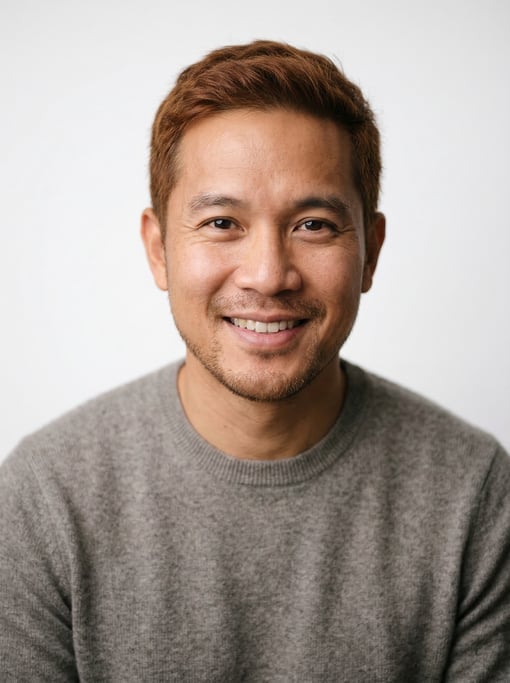 Professional studio headshot of a 37-year-old Southeast Asian man with short auburn hair