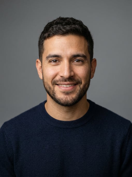 Professional studio headshot of a 29-year-old Latino man with a dark brown textured crop