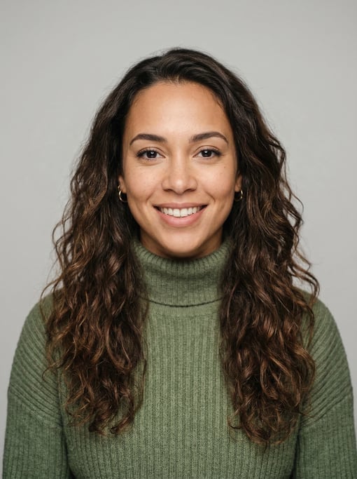 Professional studio headshot of a 27-year-old mixed-race woman with long wavy dark brown hair