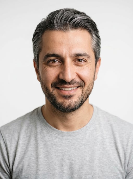 Professional studio headshot of a 38-year-old Turkish man with silver-streaked dark hair combed back