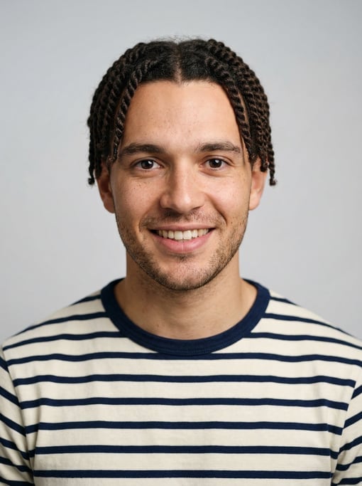 Professional studio headshot of a 24-year-old White British man with twists in dark brown
