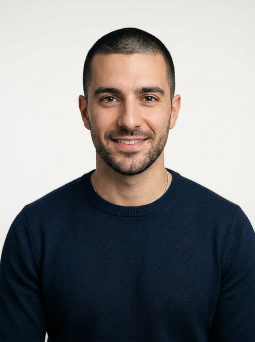 Professional studio headshot of a 29-year-old White Mediterranean man with a buzz cut in black