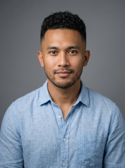 Professional studio headshot of a 27-year-old Indonesian man with a skin fade with longer curly top