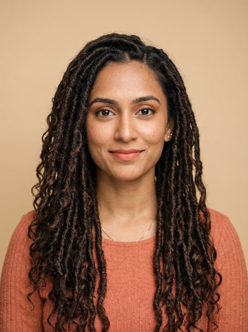 Professional studio headshot of a 29-year-old Indian woman with long goddess locs in dark brown