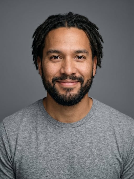 Professional studio headshot of a 36-year-old Native American man with short locs in black