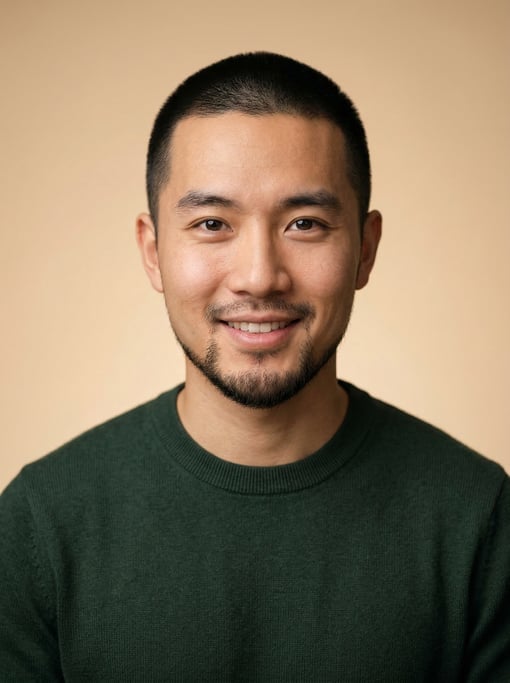 Professional studio headshot of a 24-year-old Chinese man with a buzz cut in black, a goatee