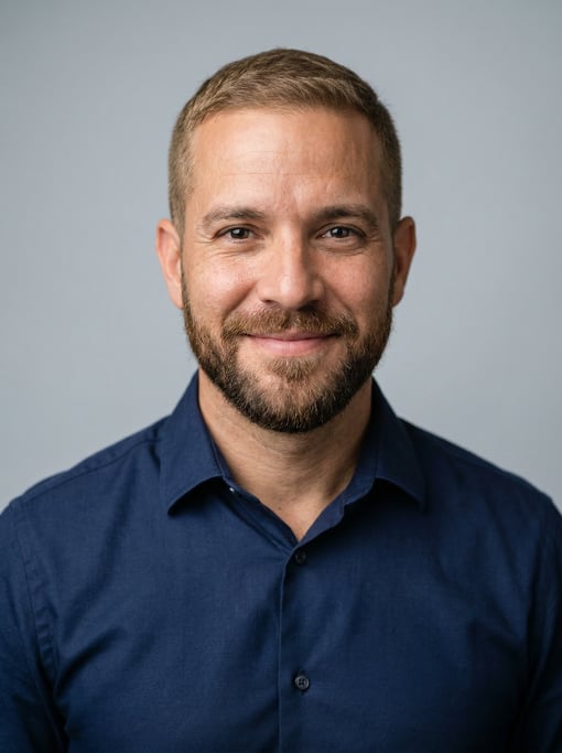 Professional studio headshot of a 38-year-old Puerto Rican man with short cropped sandy brown hair