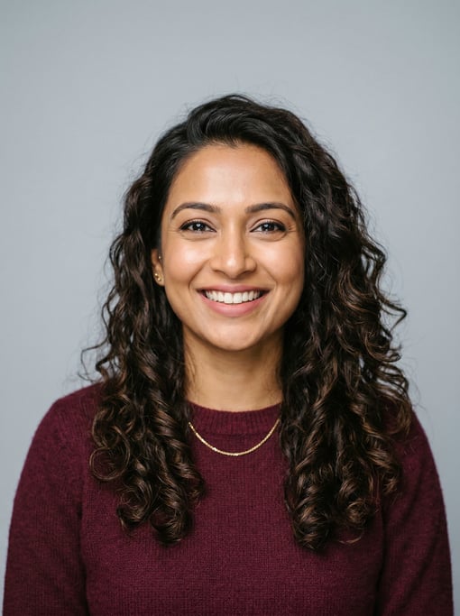 Professional studio headshot of a 31-year-old Bengali woman with long loose curls in dark brown