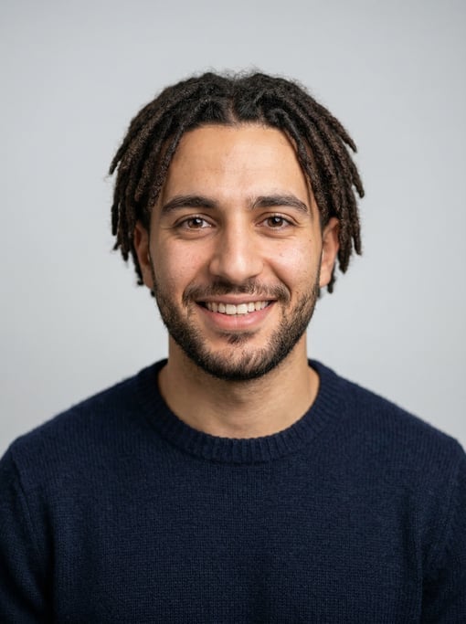 Professional studio headshot of a 24-year-old Lebanese man with short locs in dark brown