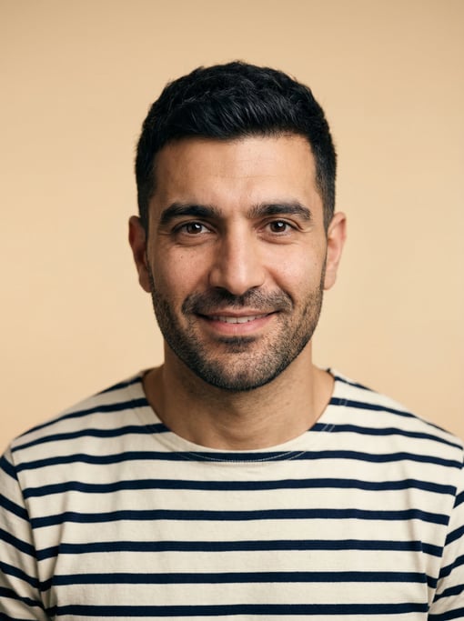 Professional studio headshot of a 36-year-old Middle Eastern man with a Caesar cut in black