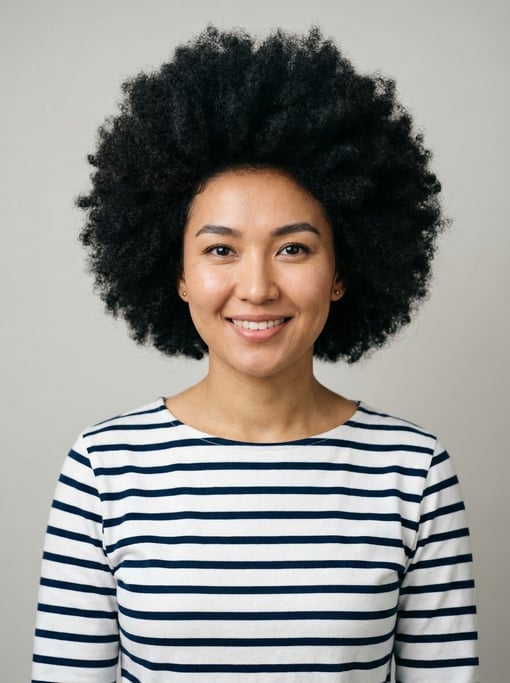 Professional studio headshot of a 25-year-old Central Asian woman with a full voluminous natural afr