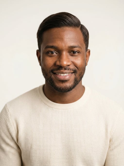 Professional studio headshot of a 29-year-old West African man with neat dark brown side-parted hair