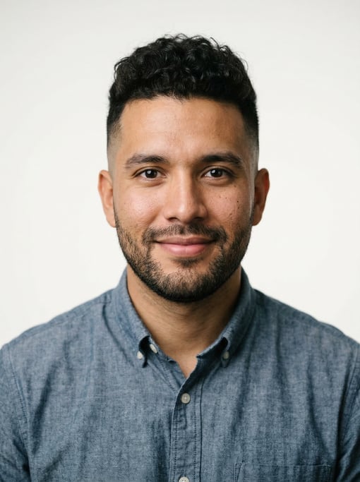 Professional studio headshot of a 25-year-old Colombian man with a skin fade with longer curly top