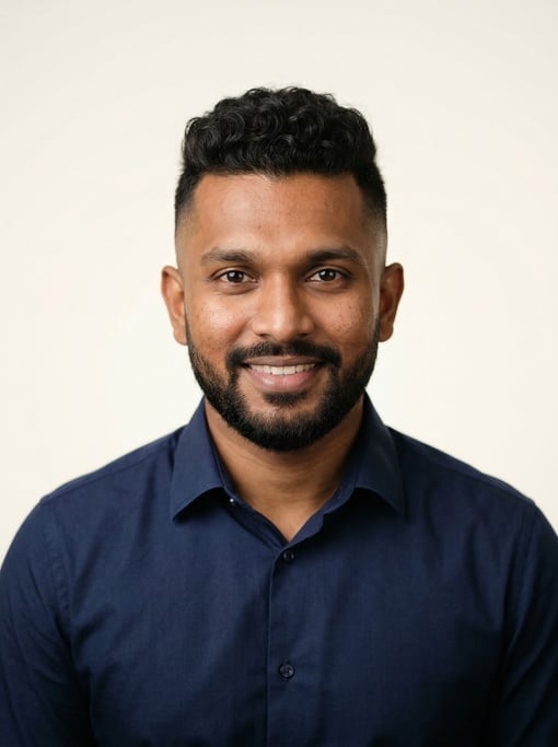 Professional studio headshot of a 29-year-old Sri Lankan man with a skin fade with longer curly top