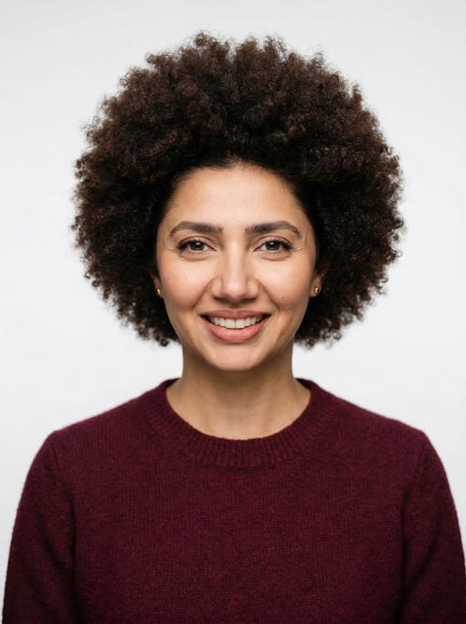 Professional studio headshot of a 37-year-old Pakistani woman with a natural afro in dark brown