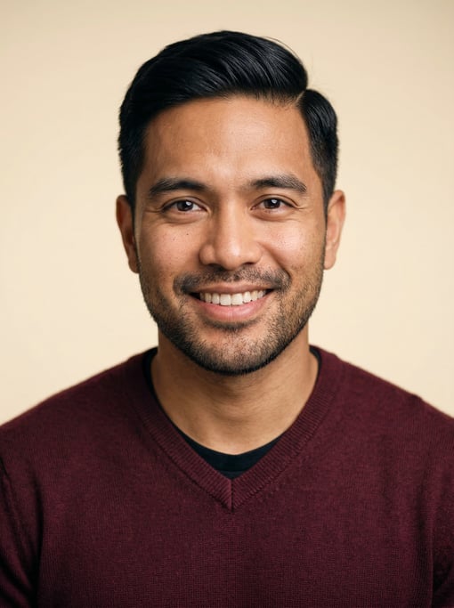 Professional studio headshot of a 28-year-old mixed-race man with neat black side-parted hair