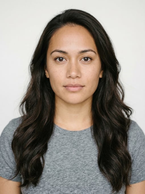 Professional studio headshot of a 25-year-old Pacific Islander woman with long wavy dark brown hair
