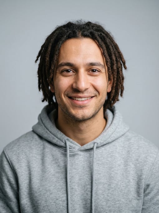 Professional studio headshot of a 25-year-old Turkish man with short locs in dark brown