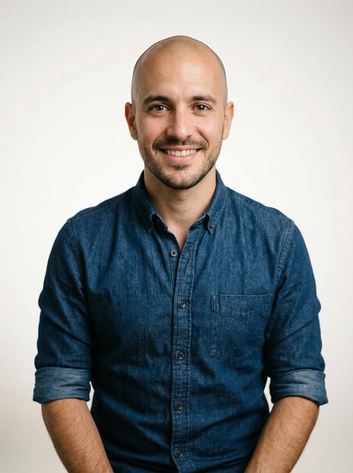 Professional studio headshot of a 30-year-old Argentinian man with a shaved head