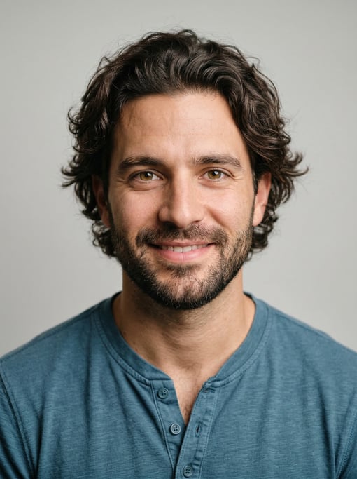 Professional studio headshot of a 28-year-old Cuban man with medium-length wavy dark brown hair