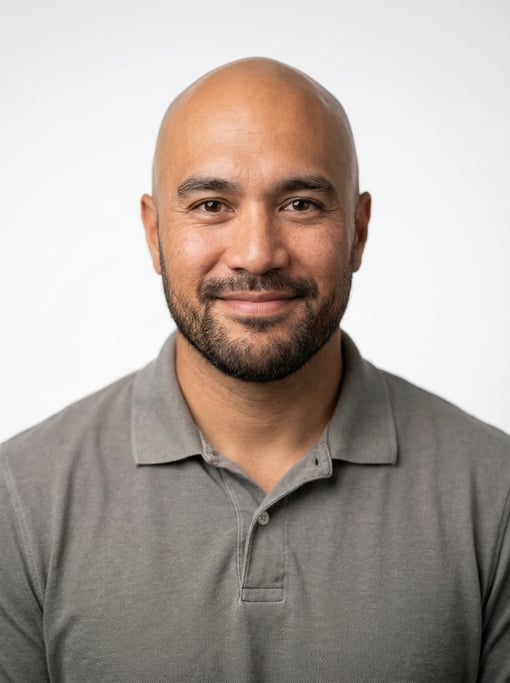 Professional studio headshot of a 36-year-old Hawaiian man with a completely bald head