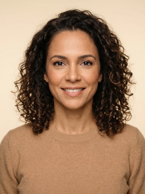 Professional studio headshot of a 40-year-old Brazilian woman with shoulder-length curly dark brown