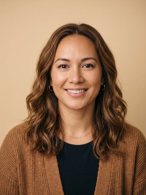 Professional studio headshot of a 33-year-old Hawaiian woman with shoulder-length wavy chestnut hair