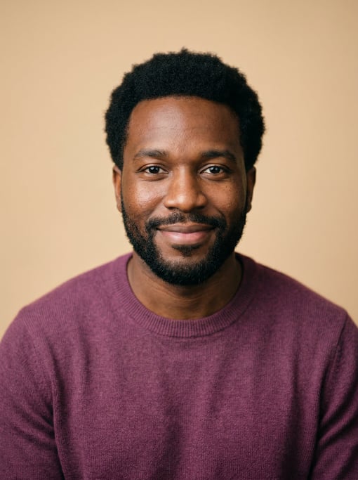 Professional studio headshot of a 33-year-old Black Caribbean man with a short natural afro in black