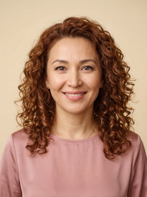 Professional studio headshot of a 40-year-old Central Asian woman with shoulder-length curly auburn