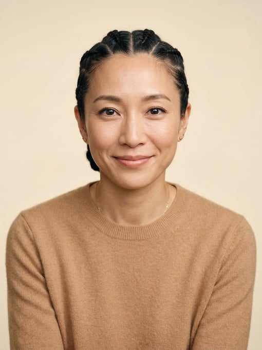 Professional studio headshot of a 39-year-old Japanese woman with cornrows pulled back neatly