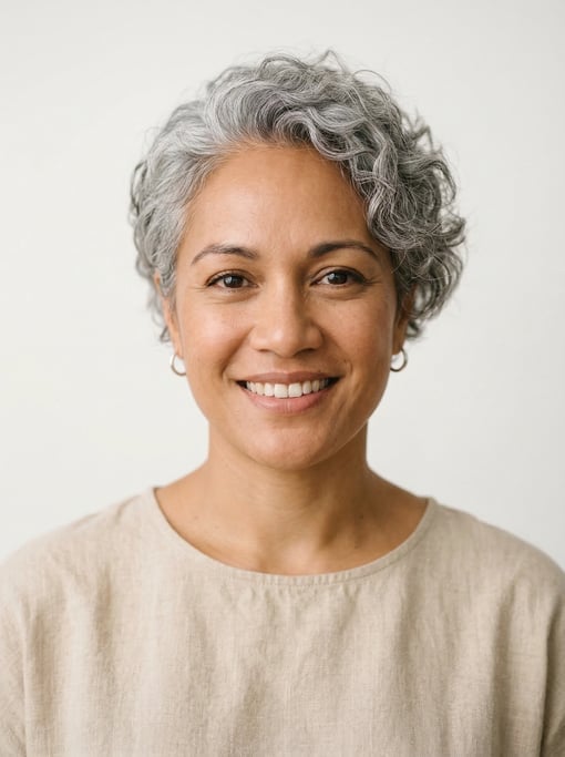 Professional studio headshot of a 34-year-old Polynesian woman with a short curly silver-grey crop