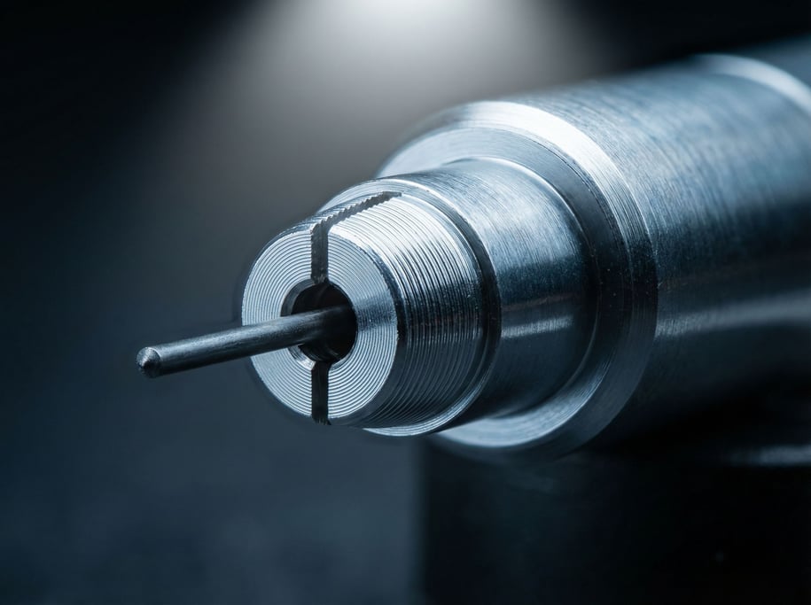 Clutch mechanism gripping a 0.5mm graphite lead: a mechanical pencil tip at extreme magnification reveals precision metal jaws with machined ridges