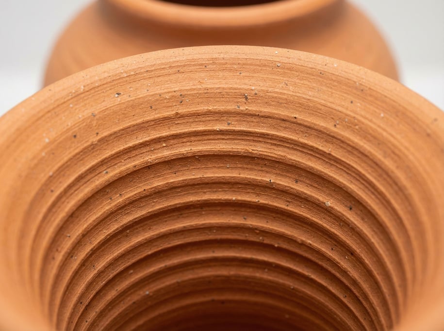 Concentric throwing rings on a pottery vase interior record the potter's fingers during forming — each ring a revolution