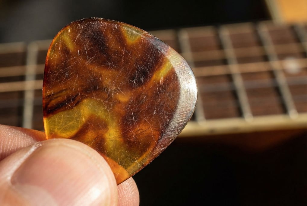 Extreme close-up of a guitar pick showing the wear pattern from playing