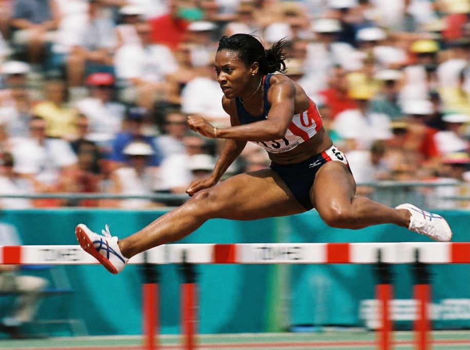 Close-up of a runner hurdling over a track hurdle, the moment of clearance