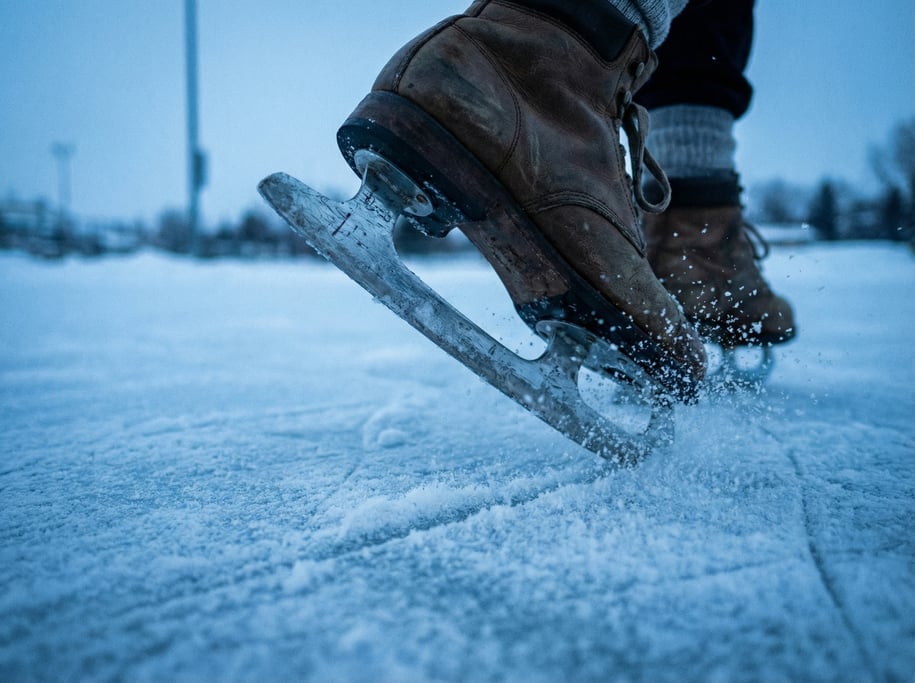 Close-up of ice skate blades on a frozen outdoor rink
