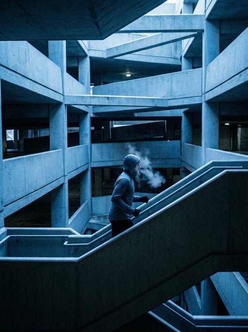 Urban runner going up a concrete staircase in a parking structure