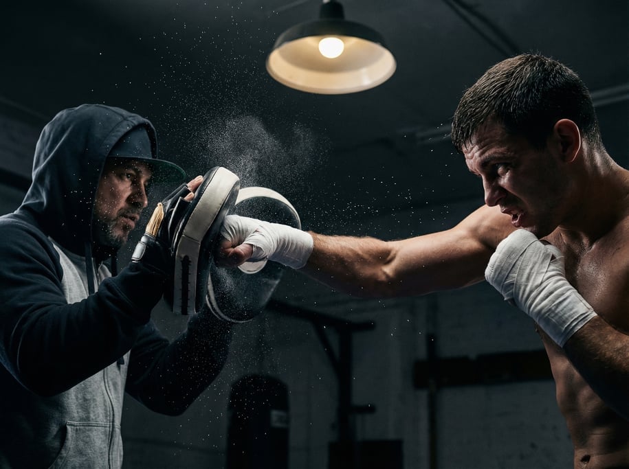 Boxer throwing a straight right, fist wrapped in white hand wraps