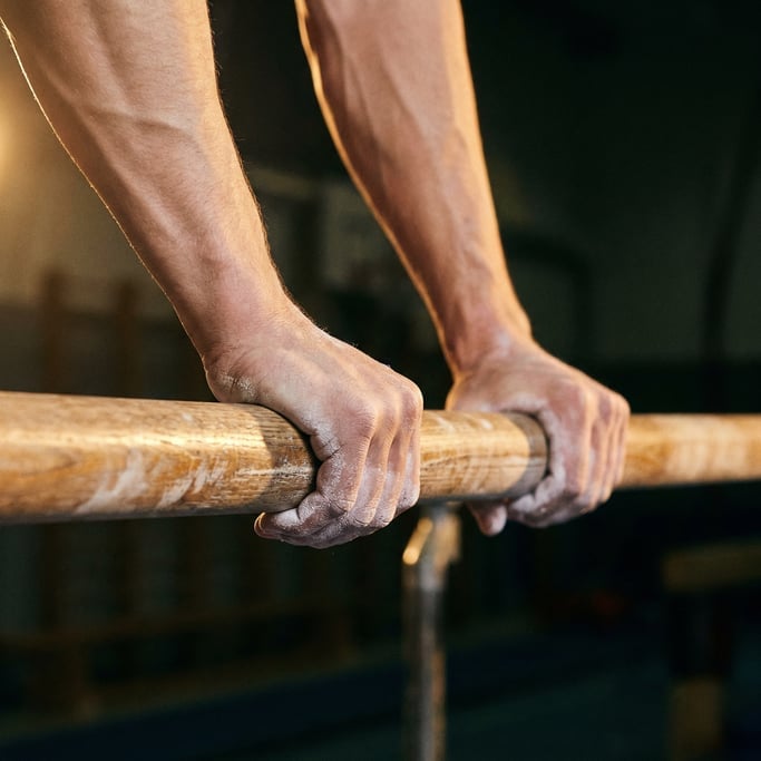 Close-up of a gymnasts hands gripping the parallel bars