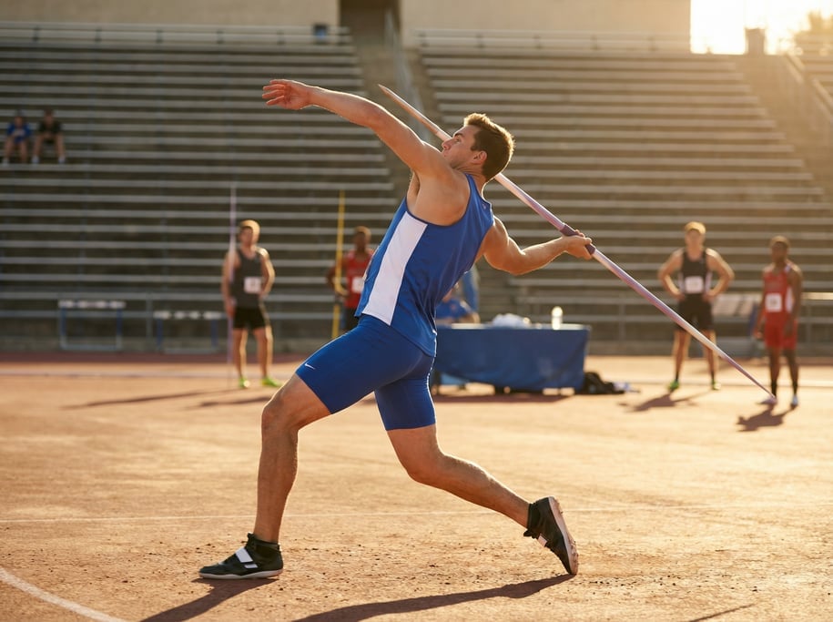 Javelin thrower at the release point, spear leaving the hand, body fully extended and twisted