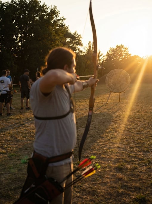 Archer at full draw, the string touching the corner of the mouth, focus on the target beyond