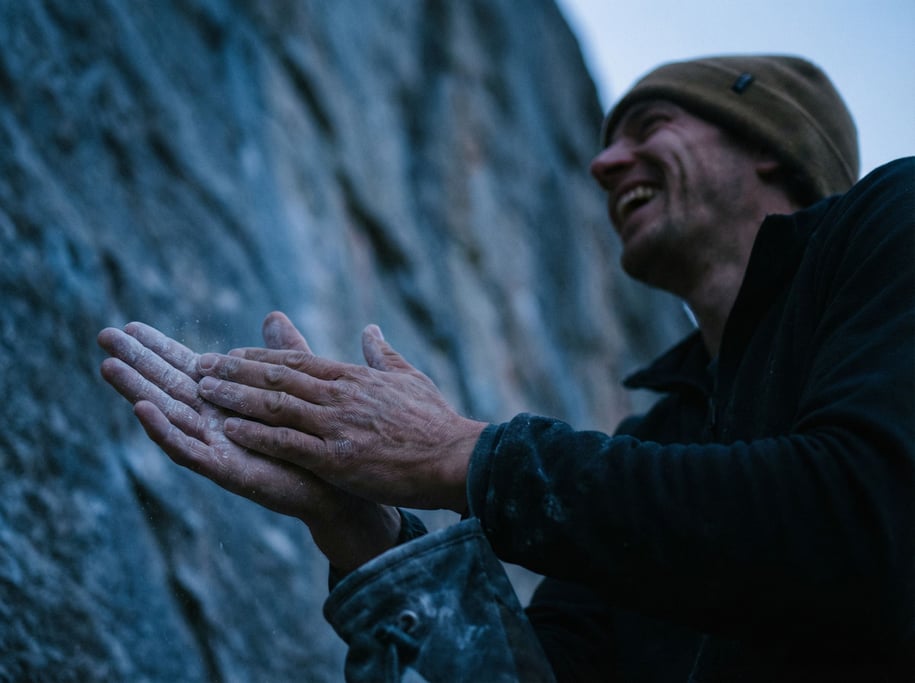 A climber chalking their hands before a route, close-up on the texture of chalk and skin (jsk3k7u)