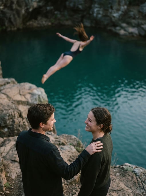 A woman diving off a cliff into turquoise water, body arched, hair trailing, time frozen (7w4kregr)