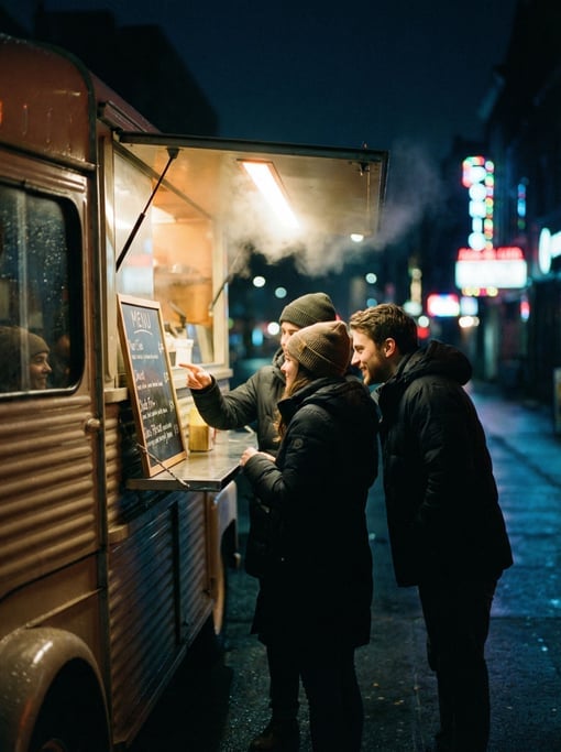 Three friends huddled around a food truck window at night